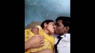 A passionate Desi couple smooching and pressing on their breasts