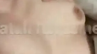 A guy presses a naked girl against his tits