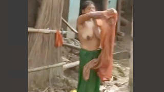 Indian wife bathes outdoors