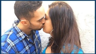 A British Indian couple engages in passionate French kissing in an erotic video