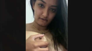 A seductive girl displays her breasts and intimate parts in a series of videos